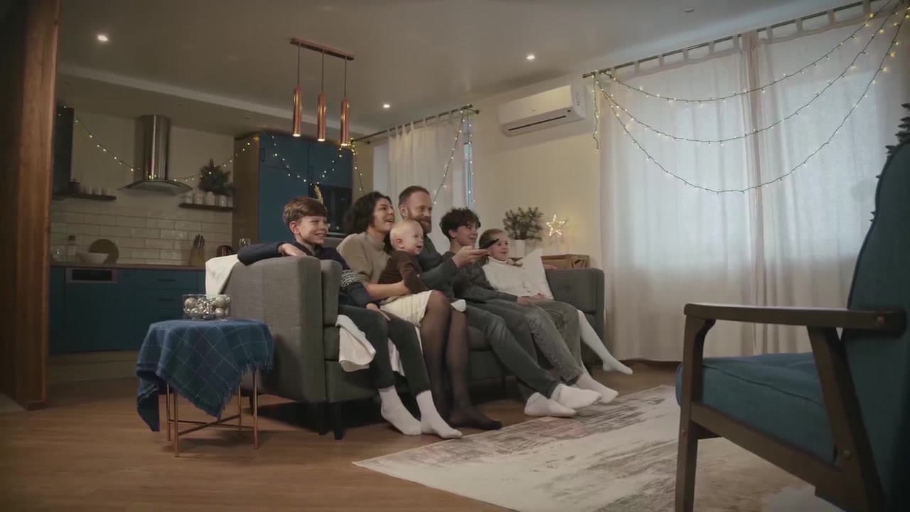 Família reunida assistindo JaguarTV na televisão